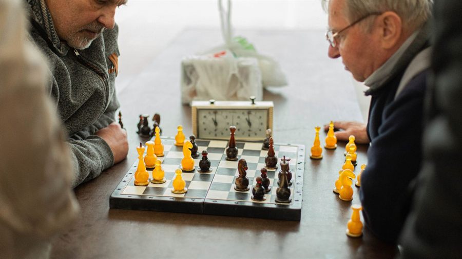 Two older men playing chess