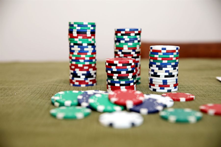 Stacks of red, blue, green and white poker chips on a green felt table